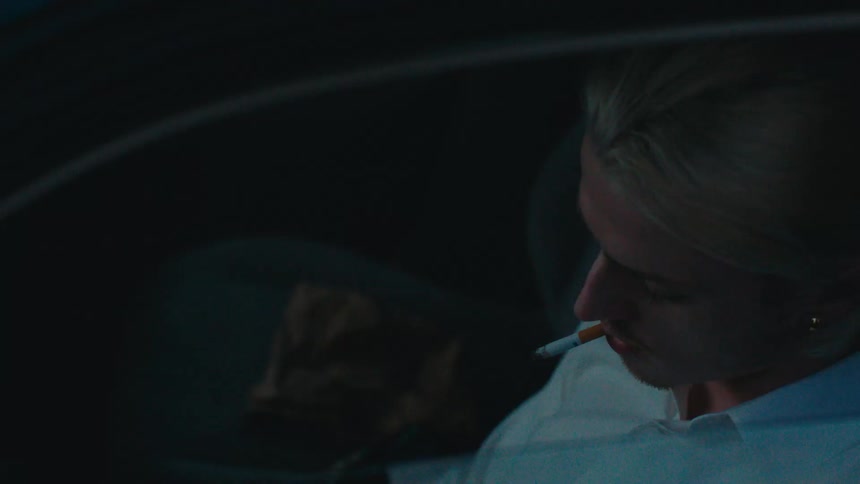 Blond man sitting smoking