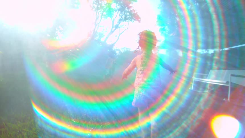 Two children running through the grass with sunlight reflection