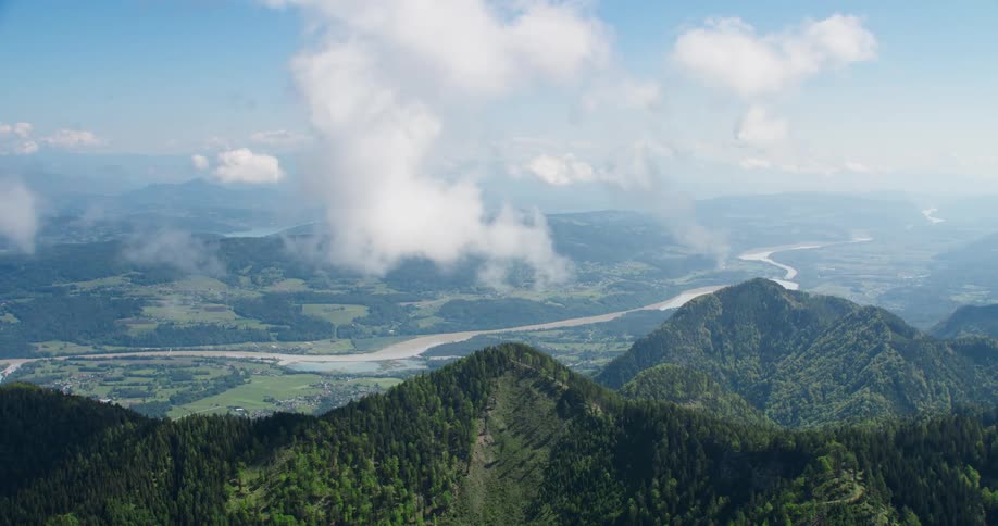 Aerial panoramic view of a mountainous landscape with a river flowing through a valley