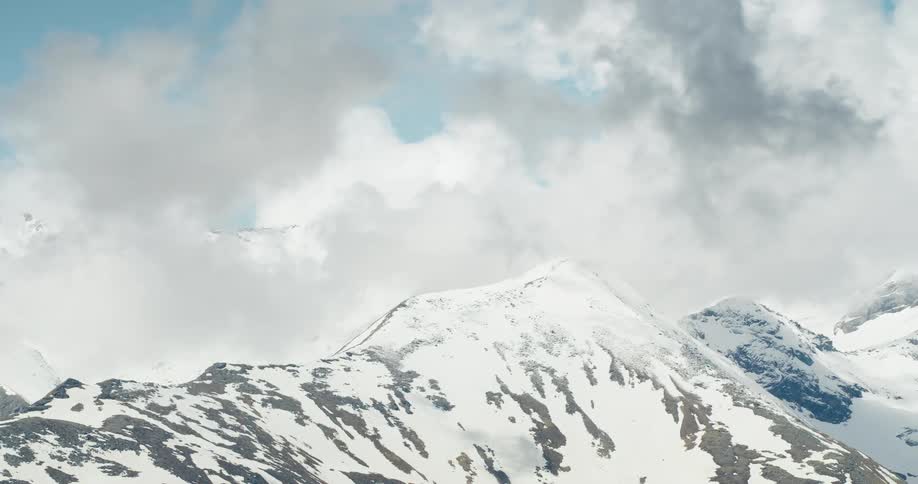 Rocky mountain ranges covered with snow and clouds