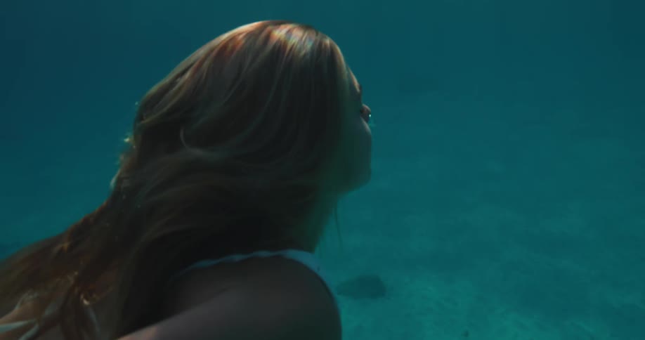 Woman swimming and releasing oxygen bubbles into the sea