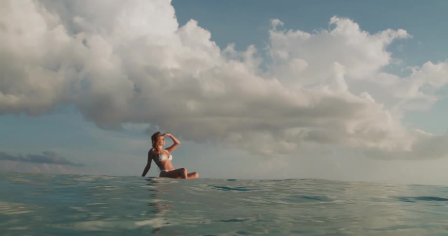 A woman is floating on a raft in the ocean