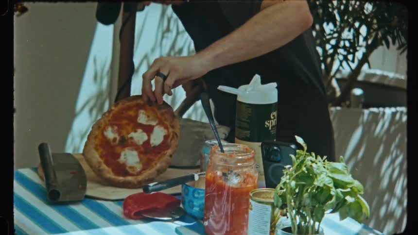 A group of friends or family cooking home made pizza in the backyard
