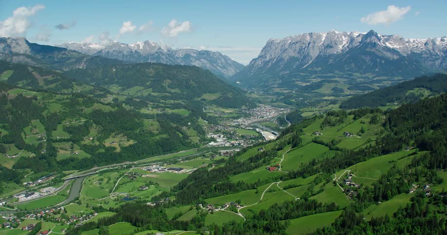 Aerial panorama of mountain ranges with village and snowy hills in the background