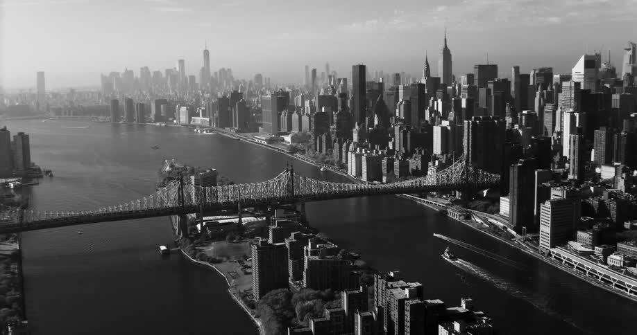 A large bridge runs over the river in the city