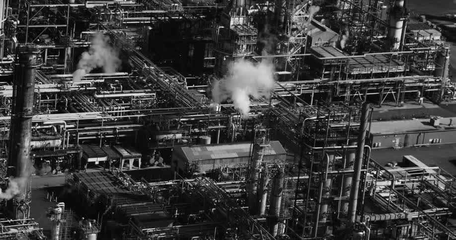 Smoke rises from a large refinery