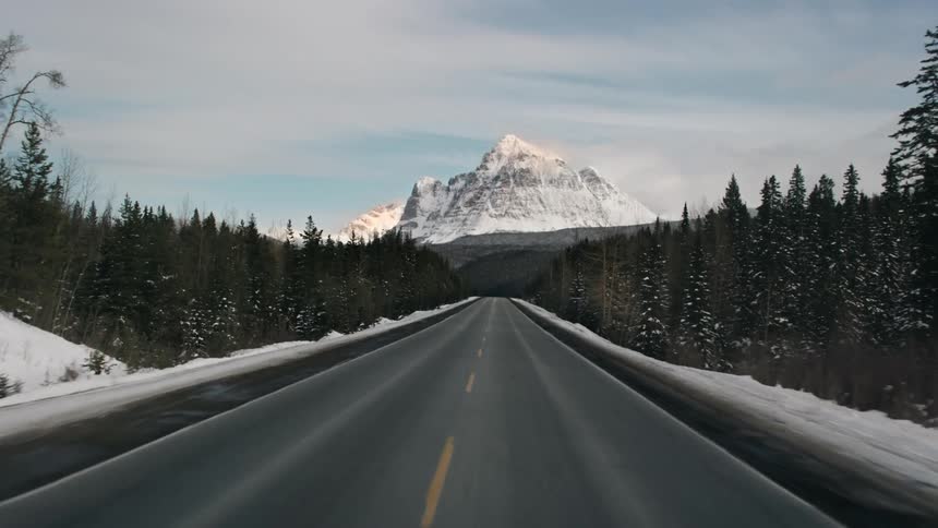 The long empty road leads to a large mountain