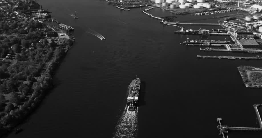 A large commercial boat sailing in a bay of water near piers