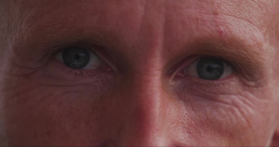 A face of a man with closed eyes and he opens his eyes