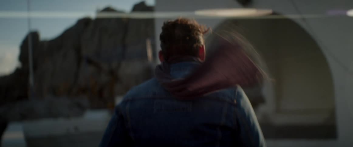 A man walks towards a structure on a windy day