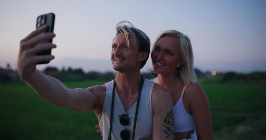 A man and woman smile and take a selfie