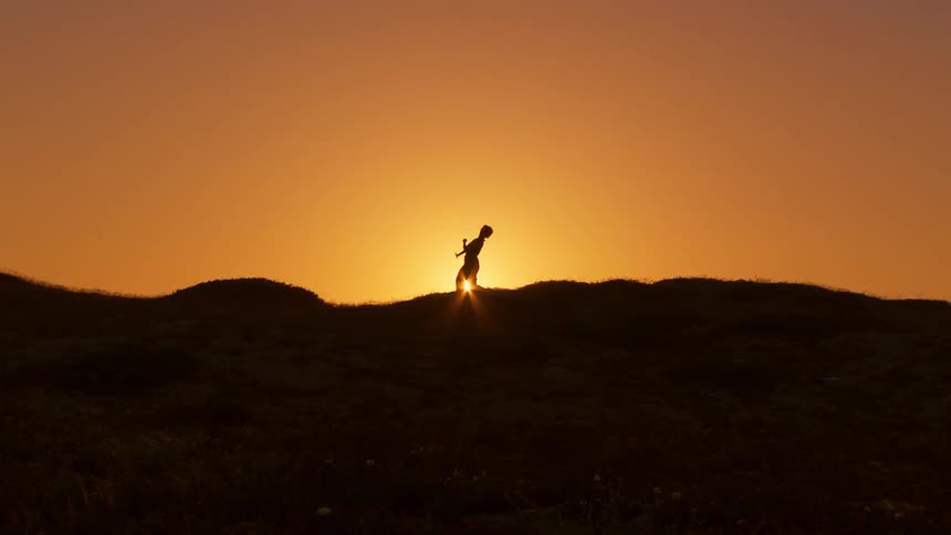 A woman is doing tai chi on the hill