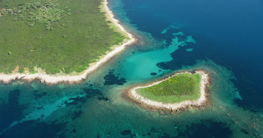 Aerial panorama of an isolated island in a vast turquoise ocean