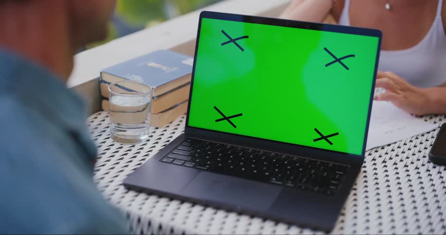 Laptop on a table with two people sitting