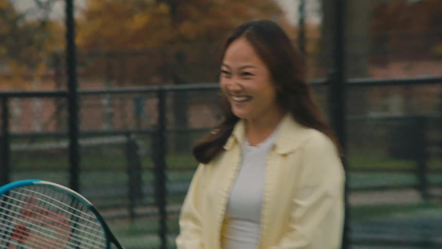 Smiling woman holding a tennis racket on the court
