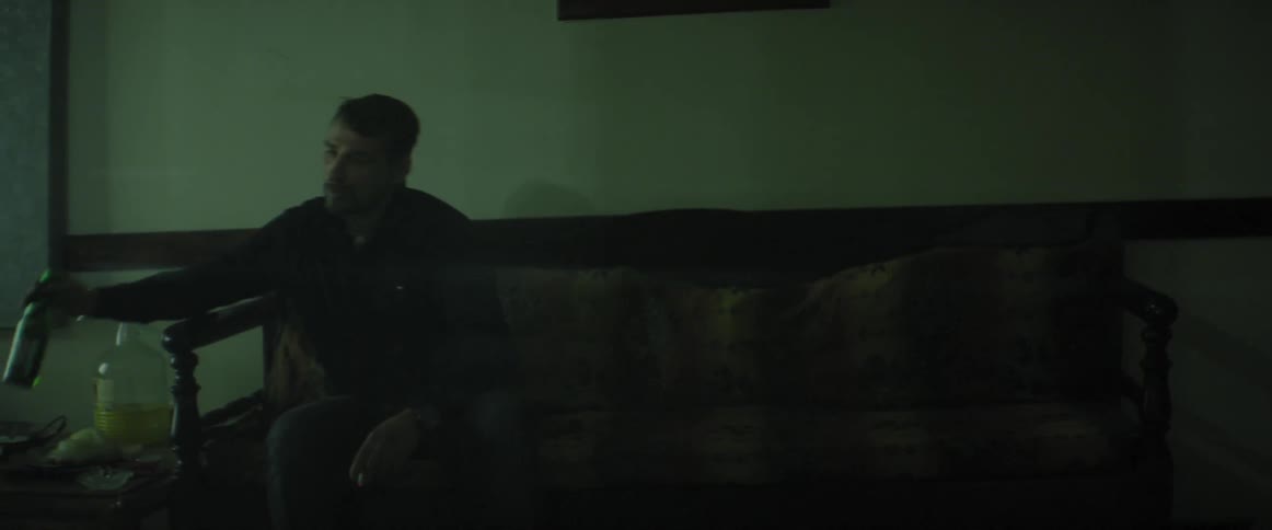 A man sits on a couch and smokes