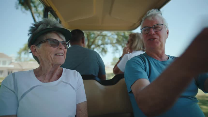 Four people ride in the golf cart