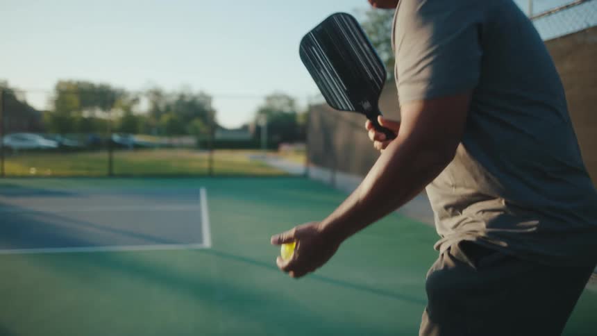 Man serving the ball during a pickleball game