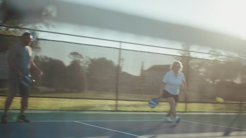 People on a tennis court playing pickleball