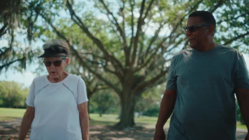 A elderly man and woman take a stroll on a nature trail