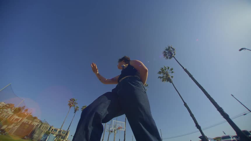 A woman dances near a suburb and parking lot