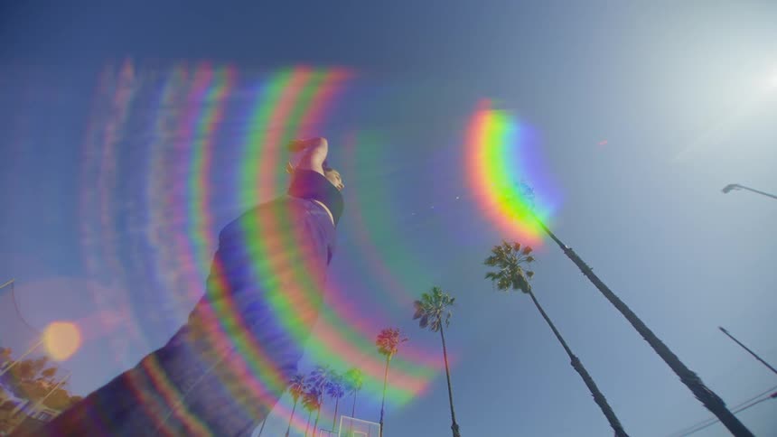 A woman is spinning and there is a strong colored light in front of her