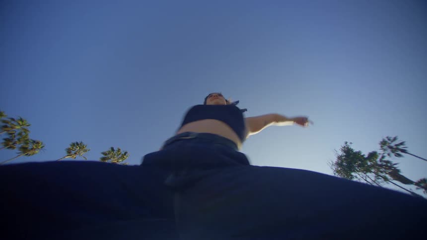 A woman dances frenetically outdoors