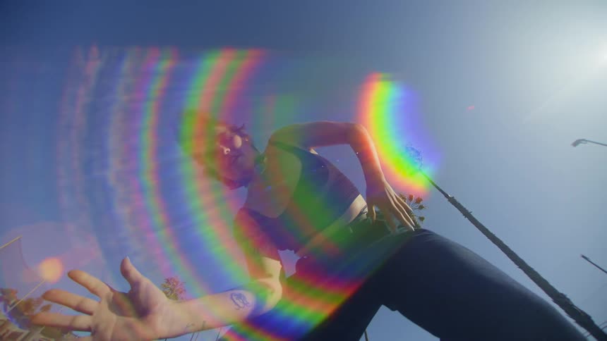 Upward view of a woman dancing on a clear blue sky day