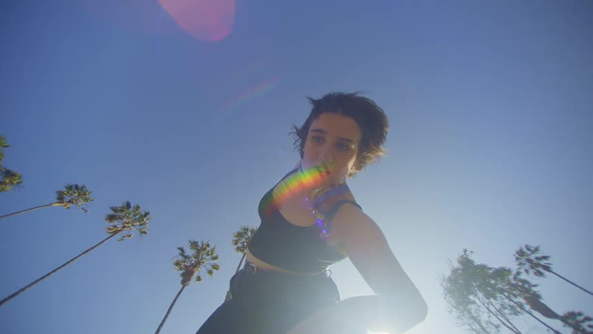 Woman dancing in an openair environment with palm trees around