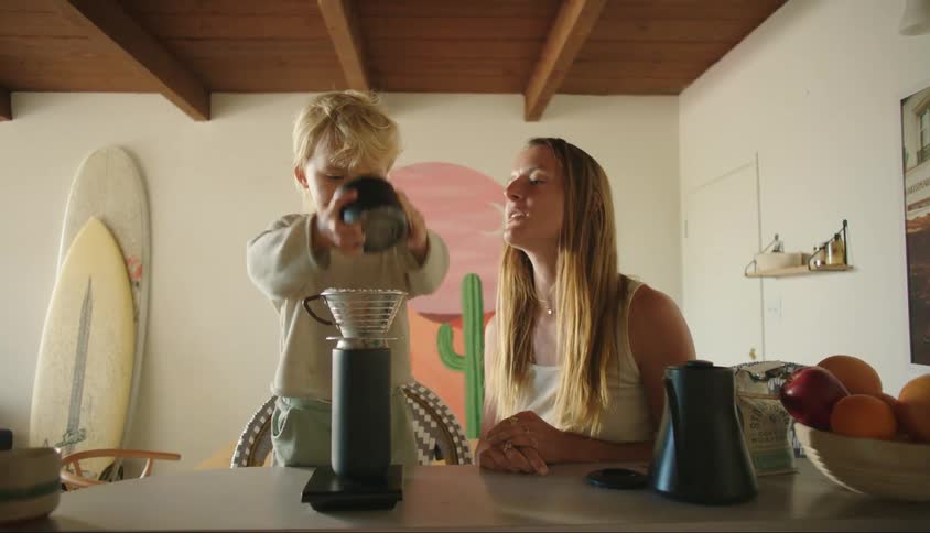Mother and son make coffee indoors