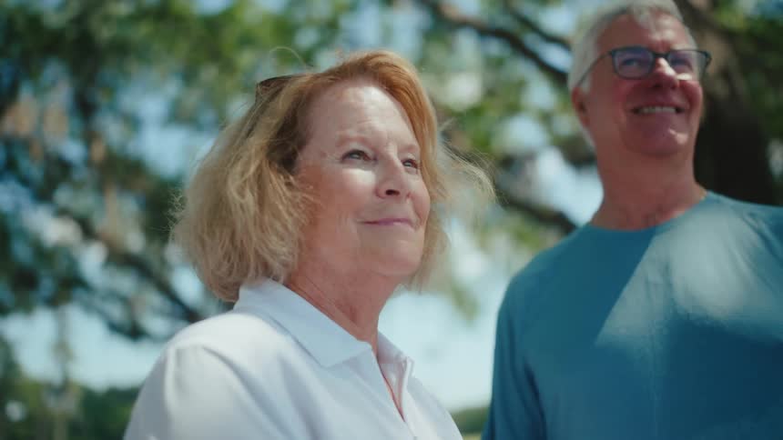 A man and woman are smiling outside