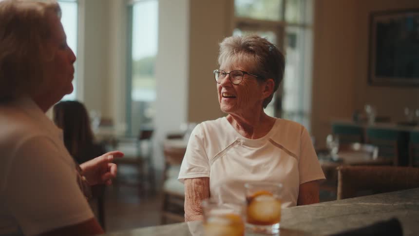 Two elderly women sitting in a restaurant talking