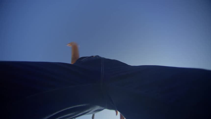 A female performs dance moves outdoors at midday
