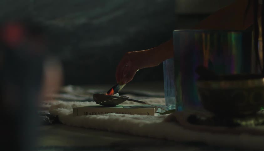 Hand holding a wood over a candle flame