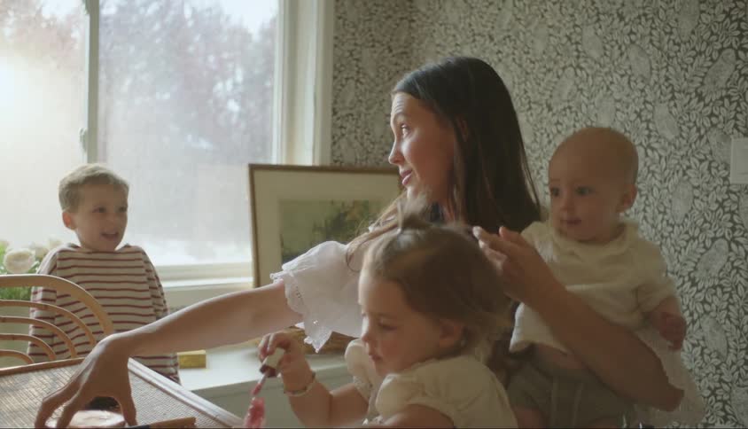 Mother talks to her children while she puts on makeup