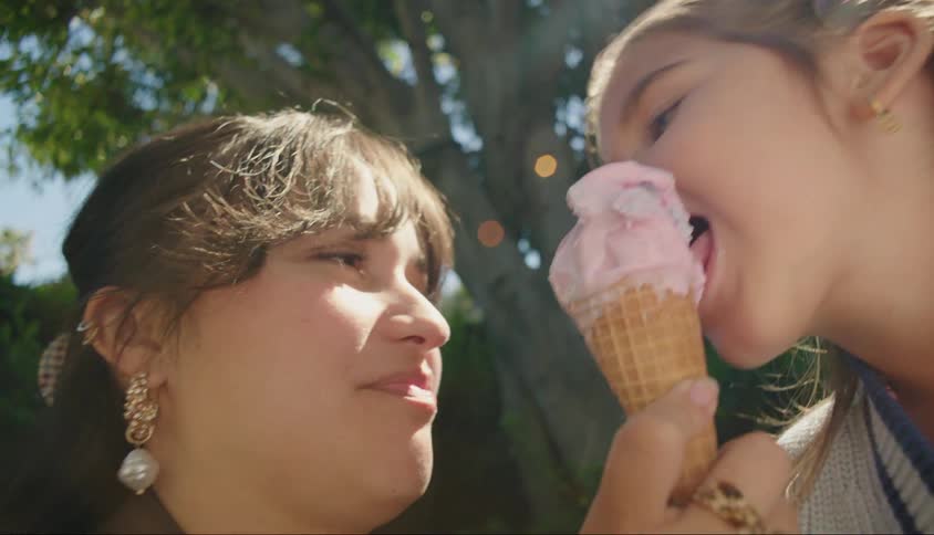 Portrait of a woman sharing an ice cream with a little girl