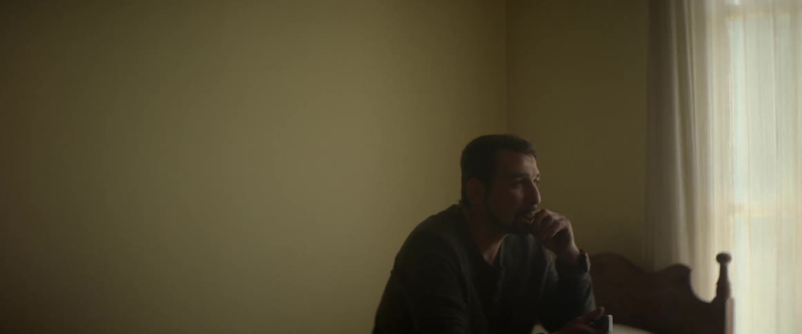 A man sitting on a bed lights cigarette
