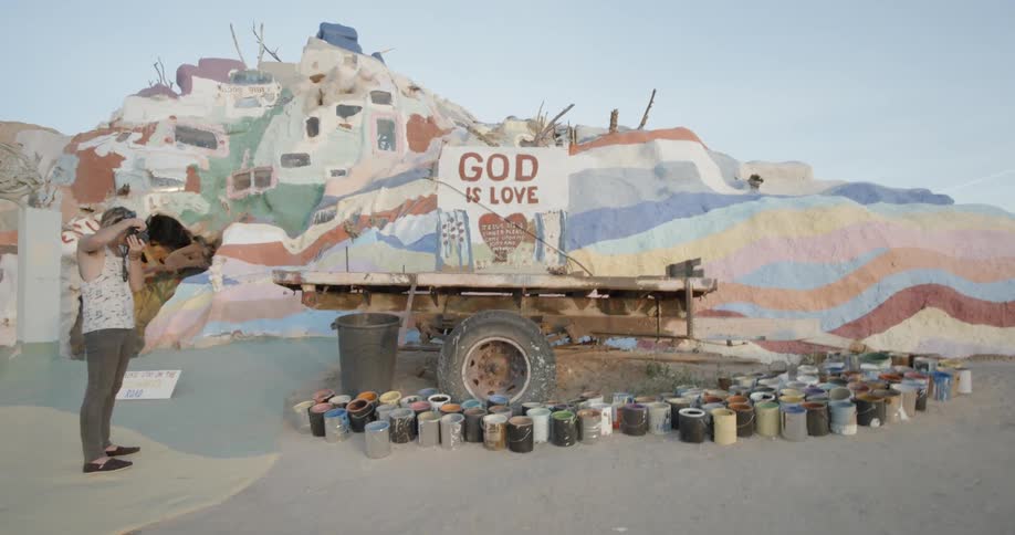 A man takes a picture of a memorial sculpture