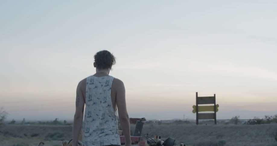 A man walking on the beach at sunset