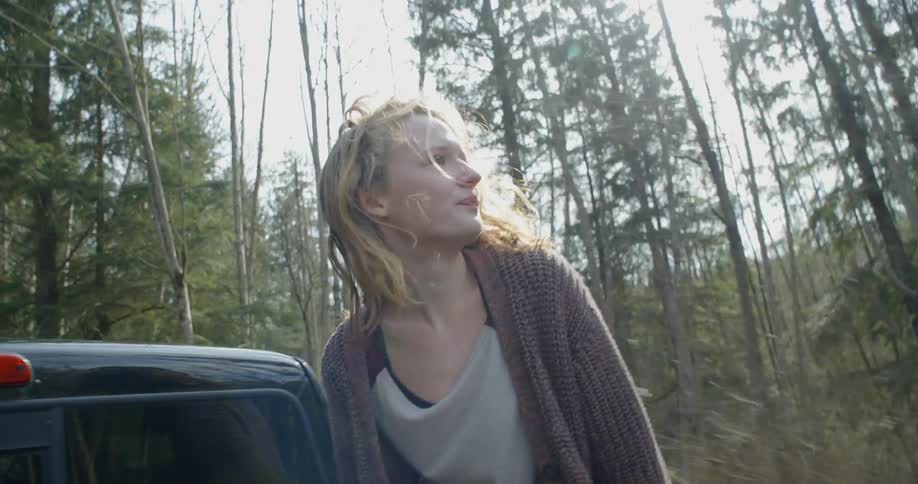 A woman rides in the back of a truck