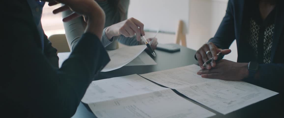 Coworkers discuss documents during a meeting