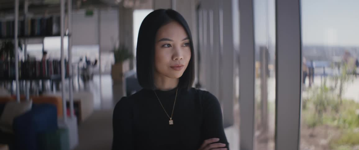 A woman stands by the window