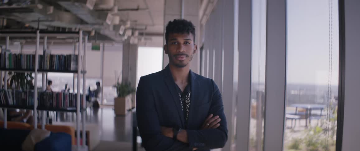 A man is standing by the window in the office