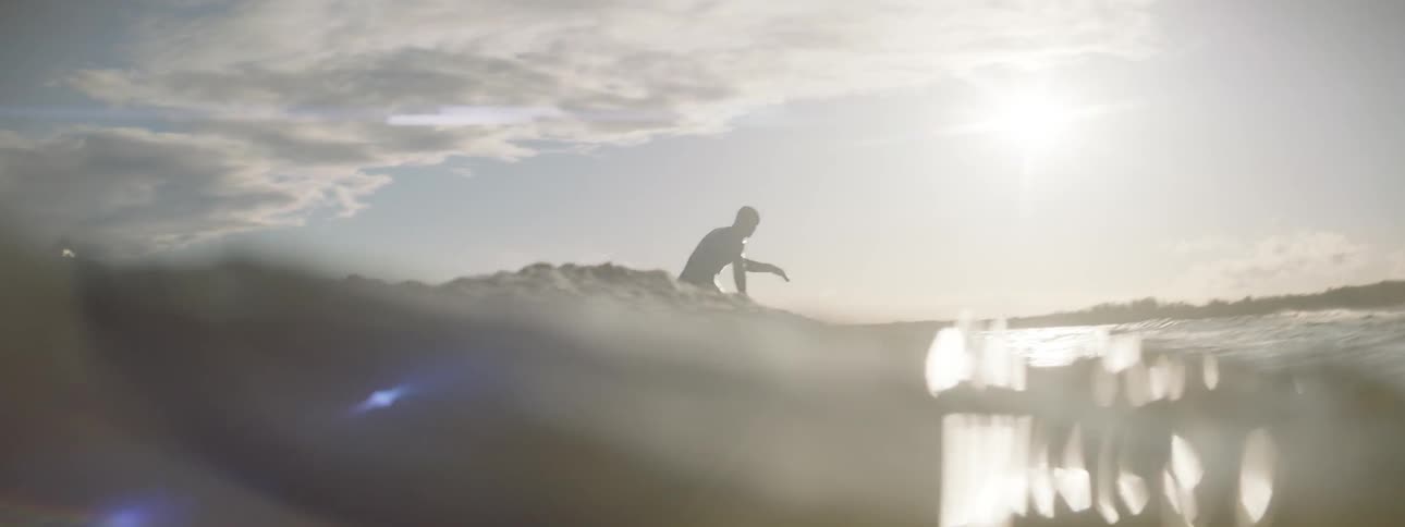 Surfer riding a small wave as seen from water level