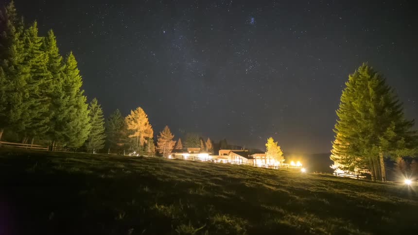 Scenery of illuminated houses at night in a field on a starry day