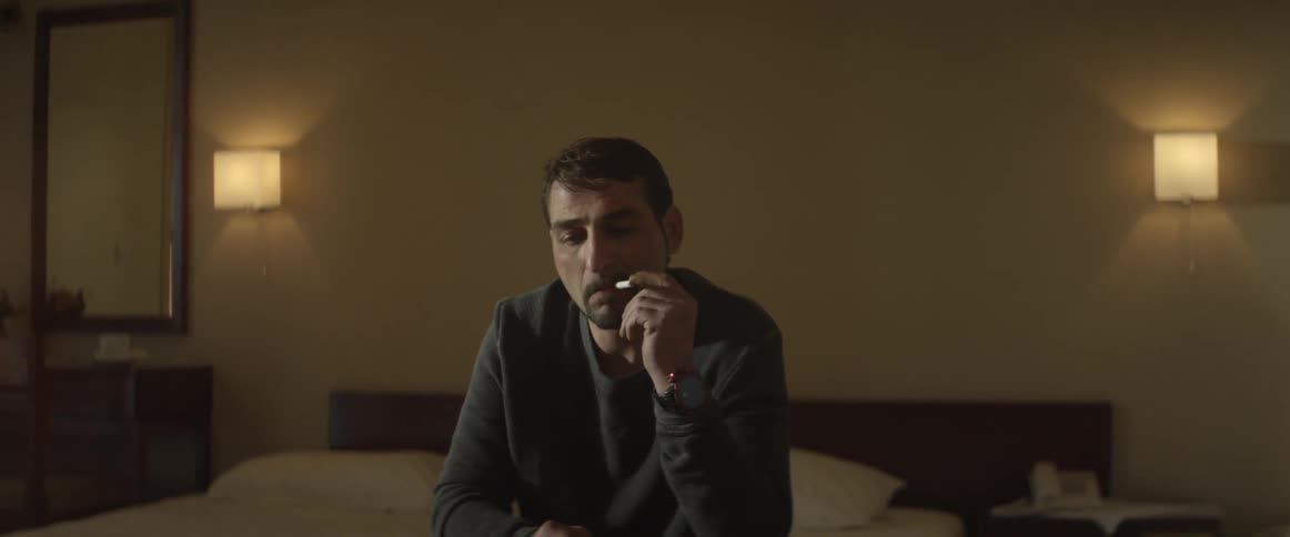 Man sitting on a bed smoking