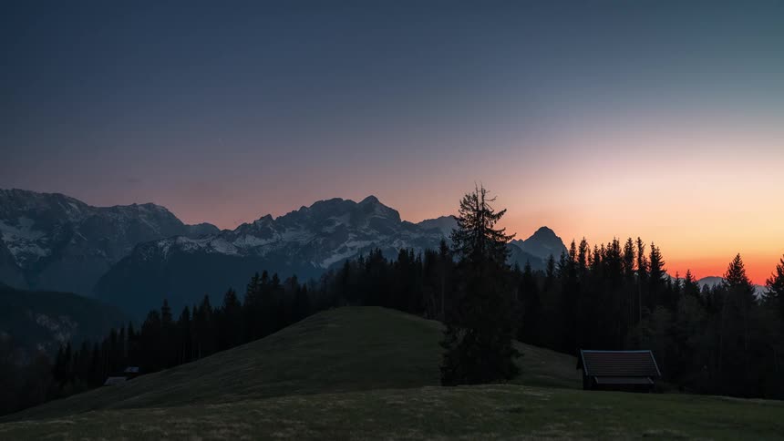 A landscape of a rural region with dense clouds passing in the sky and then it gets dark and the sky becomes starry