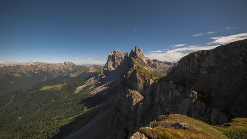 Clouds pass over a mountain range and reveal clear skies