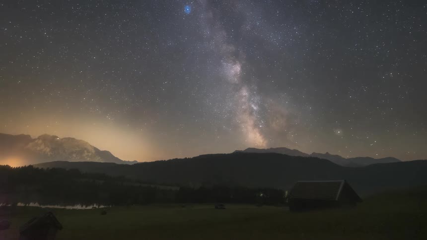 The milky way galaxy moves through the sky over a rural area