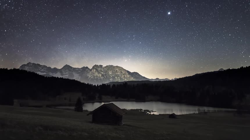 A rural region with a cabin at night and the sky is full of stars and time is passing quickly